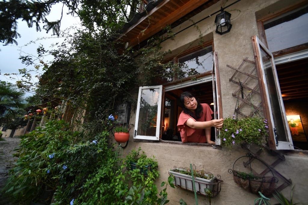 8月29日，在福建省屏南縣熙嶺鄉(xiāng)，龍?zhí)洞濉靶麓迕瘛泵泛暝诖蚶碜约航?jīng)營(yíng)的民宿外墻裝飾花盆。新華社記者姜克紅 攝