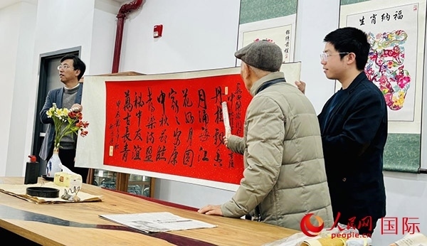 旅秘書(shū)法家向現(xiàn)場(chǎng)觀眾展示書(shū)法作品。人民網(wǎng)記者 宋亦然攝