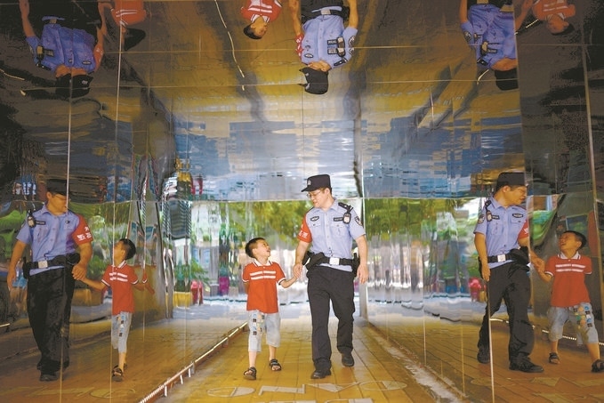 ?7月16日，重慶市公安局江北區(qū)分局一名民警在巡邏途中遇到一個(gè)獨(dú)自玩耍的小男孩，民警將其送回家。王洪平攝