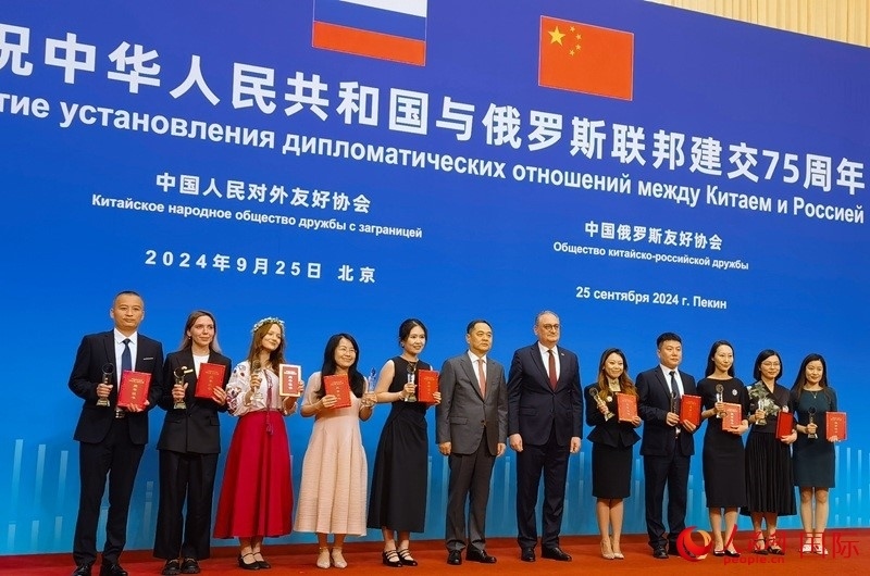 楊萬(wàn)明會(huì)長(zhǎng)和莫爾古洛夫大使為10位中俄青年友好微視頻創(chuàng)意大賽獲獎(jiǎng)代表頒獎(jiǎng)。人民網(wǎng)記者 李明琪攝