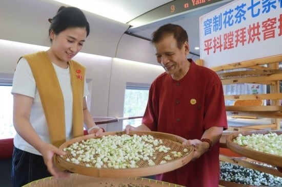 10月1日，福州市茉莉花茶窨制工藝代表性傳承人張子建與旅客在G1634次列車上制作茉莉花茶。新華社記者周義 攝