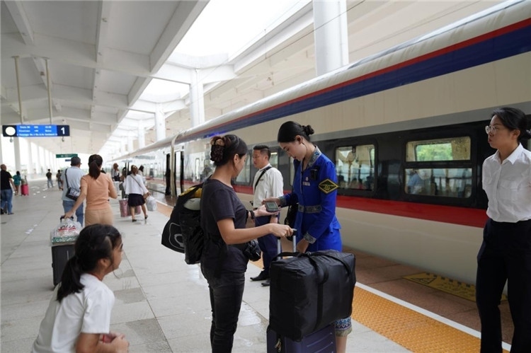 中老鐵路工作人員在站臺指引旅客進站乘車。老中鐵路有限公司供圖
