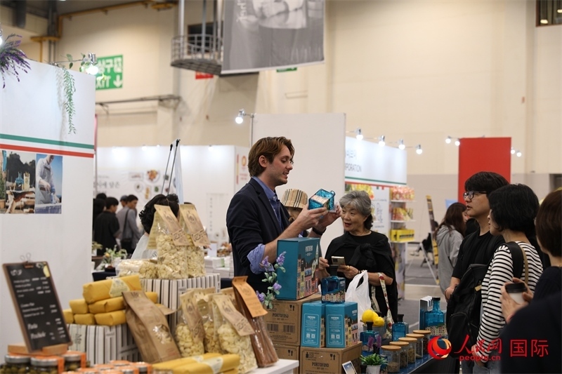當(dāng)?shù)貢r(shí)間10月5日，在第21屆釜山國(guó)際美食博覽會(huì)上，意大利展商向參觀者們介紹的意大利食品。人民網(wǎng)記者 莽九晨攝