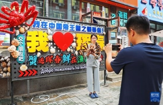 9月21日，游客在吉林省琿春市一處帝王蟹元素主題裝飾前拍照留念。新華社發(fā)