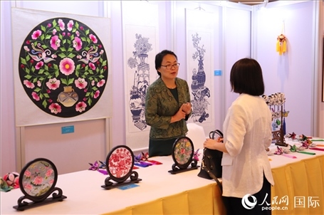 青海非遺文化傳承人向嘉賓介紹展品。人民網(wǎng)實(shí)習(xí)生姚欣可攝