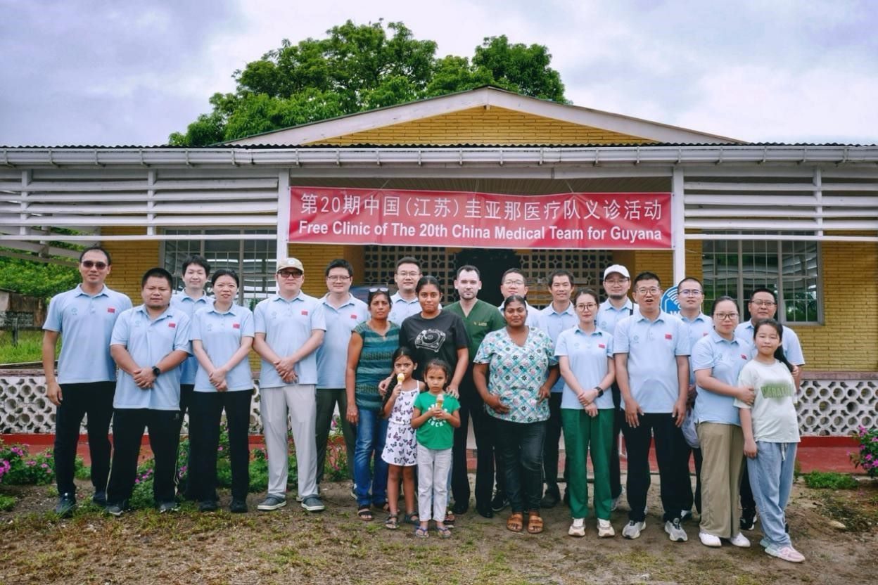 第20期中國（江蘇）援圭亞那醫(yī)療隊在圭偏遠的林登高速社區(qū)開展義診后，與部分當?shù)鼐用窈嫌啊?中國援圭醫(yī)療隊供圖