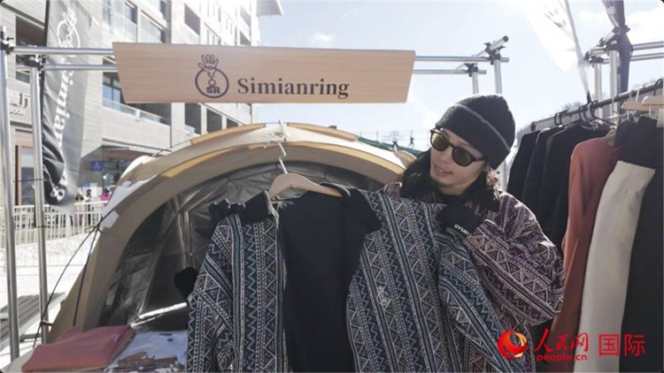 藤田周正在展示自己設(shè)計(jì)的滑雪服。人民網(wǎng)記者 袁蒙攝