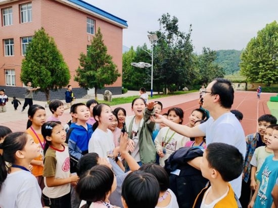 孩子們在操場和老師一起試飛無人機（沈怡辰 攝）