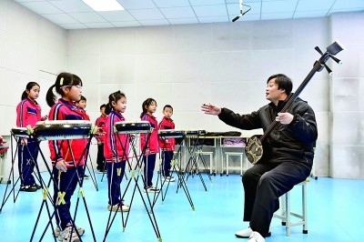 圖為12月30日，在惠民縣胡集鎮(zhèn)第一小學(xué)，老師指導(dǎo)學(xué)生學(xué)習(xí)西河大鼓。新華社記者 郭緒雷攝