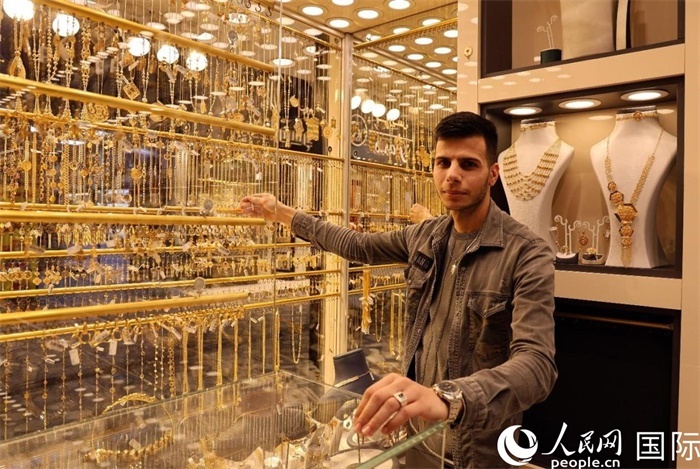 一名銷售員展示黃金飾品。人民網(wǎng) 伊納斯·易卜拉欣攝