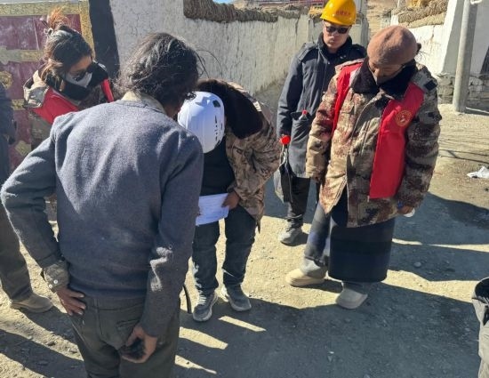 1月13日，次旺（右一）陪同工作組走訪村莊，評(píng)估房屋受損程度。新華社發(fā)