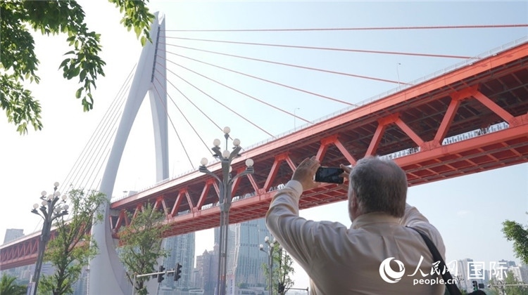 軻寶華“打卡”重慶東水門長江大橋。人民網(wǎng)記者 蘇纓翔攝