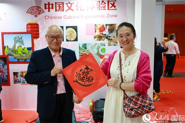 本地觀眾在中國文化體驗區(qū)展示書法作品。人民網(wǎng)記者 白元琪攝