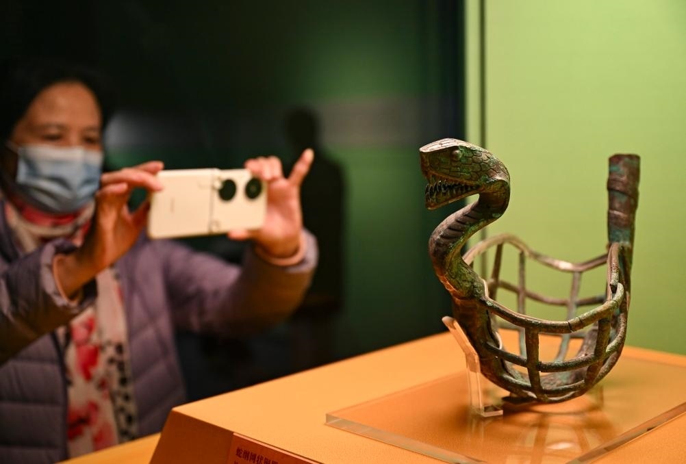 1月14日，觀眾在上海博物館蛇年迎春展拍攝展品蛇綱網(wǎng)狀銅器。新華社發(fā)（陳浩明攝）