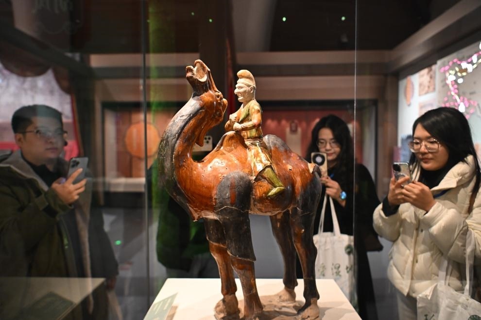 1月15日，觀眾在拍攝“長(zhǎng)安三萬(wàn)里——陜西唐代文物精華展”展出的三彩胡人騎駝俑。（新華社記者 孫凡越 攝）