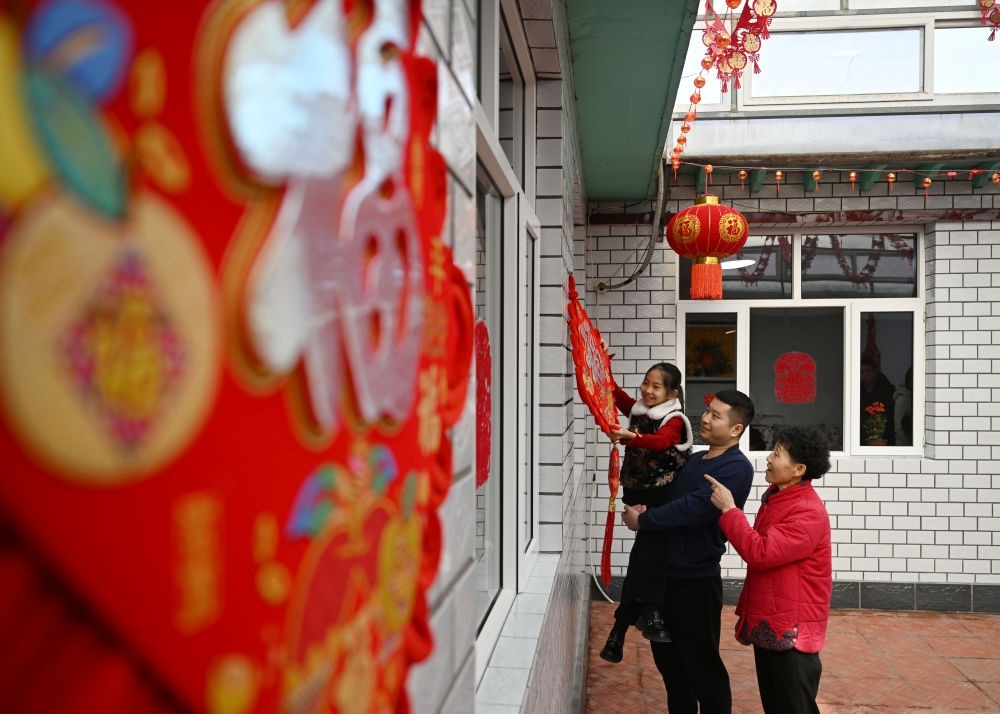 天津市西青區(qū)辛口鎮(zhèn)第六埠村村民在院子里掛“福”字（2024年2月1日攝）。新華社記者 趙子碩 攝