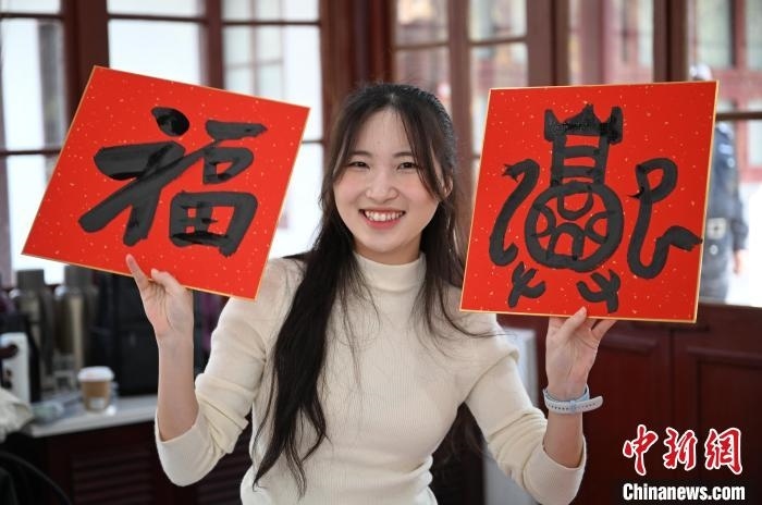 1月20日，馬來(lái)西亞留學(xué)生展示其創(chuàng)作的福貼。當(dāng)日，來(lái)自巴西、馬來(lái)西亞、加納、哈薩克斯坦的外籍留學(xué)生在浙江杭州西泠印社體驗(yàn)福貼、春聯(lián)和篆刻，感受古老的中國(guó)傳統(tǒng)文化。中新社記者 王剛 攝