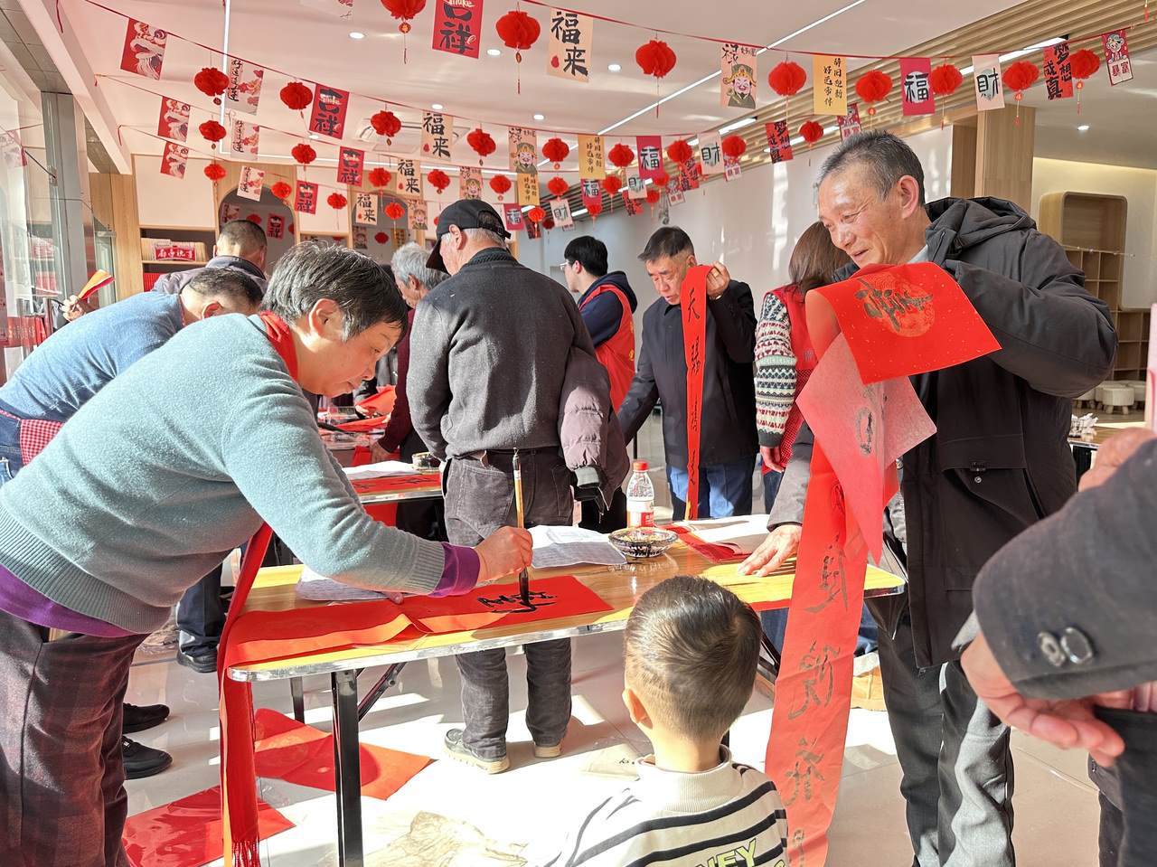 今年春節(jié)前夕，慶元縣濛洲街道同濟(jì)新村，一場送春聯(lián)活動(dòng)熱鬧舉行。慶元縣融媒體中心 供圖