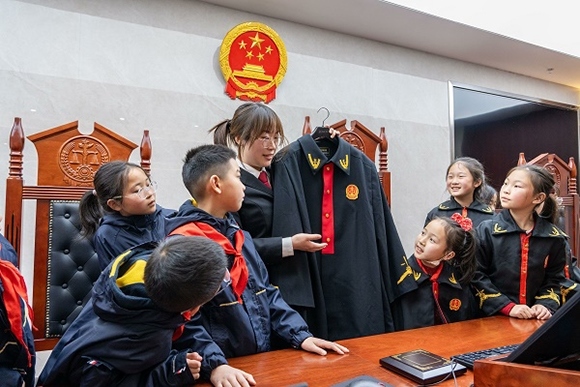 圖②：干警向同學們介紹法袍。