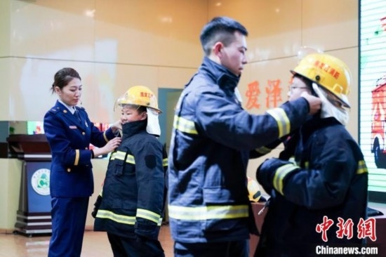圖為學(xué)生們現(xiàn)場(chǎng)穿戴消防頭盔和戰(zhàn)斗服。中新社記者 趙宇航 攝