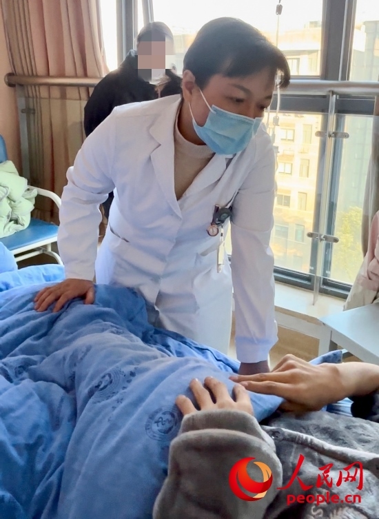 鄧茜查房時(shí)詢問患者情況。人民網(wǎng)記者 金慧慧攝