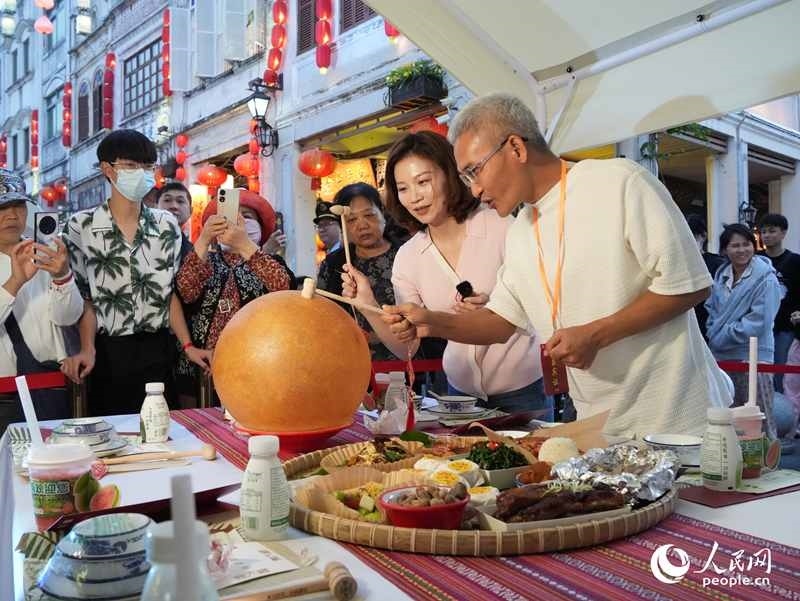 嘉賓品嘗海南傳統(tǒng)美食“煎堆”。人民網(wǎng)記者 張力洋攝