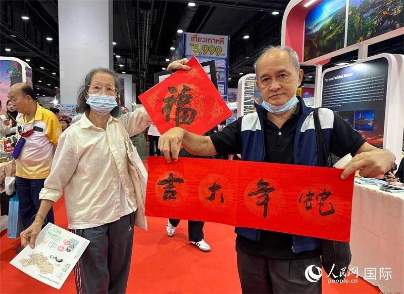 2025蛇年春節(jié)，泰國(guó)市民展示他們領(lǐng)到的華人手寫(xiě)春聯(lián)。人民網(wǎng)記者 簡(jiǎn)承淵攝