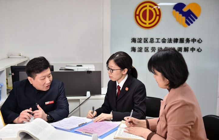 2025年3月6日，在北京市海淀區(qū)總工會勞動爭議調(diào)解中心，海淀區(qū)人民法院法官王琰（中）與該中心工作人員就糾紛化解情況進行溝通。新華社記者 趙婷婷 攝