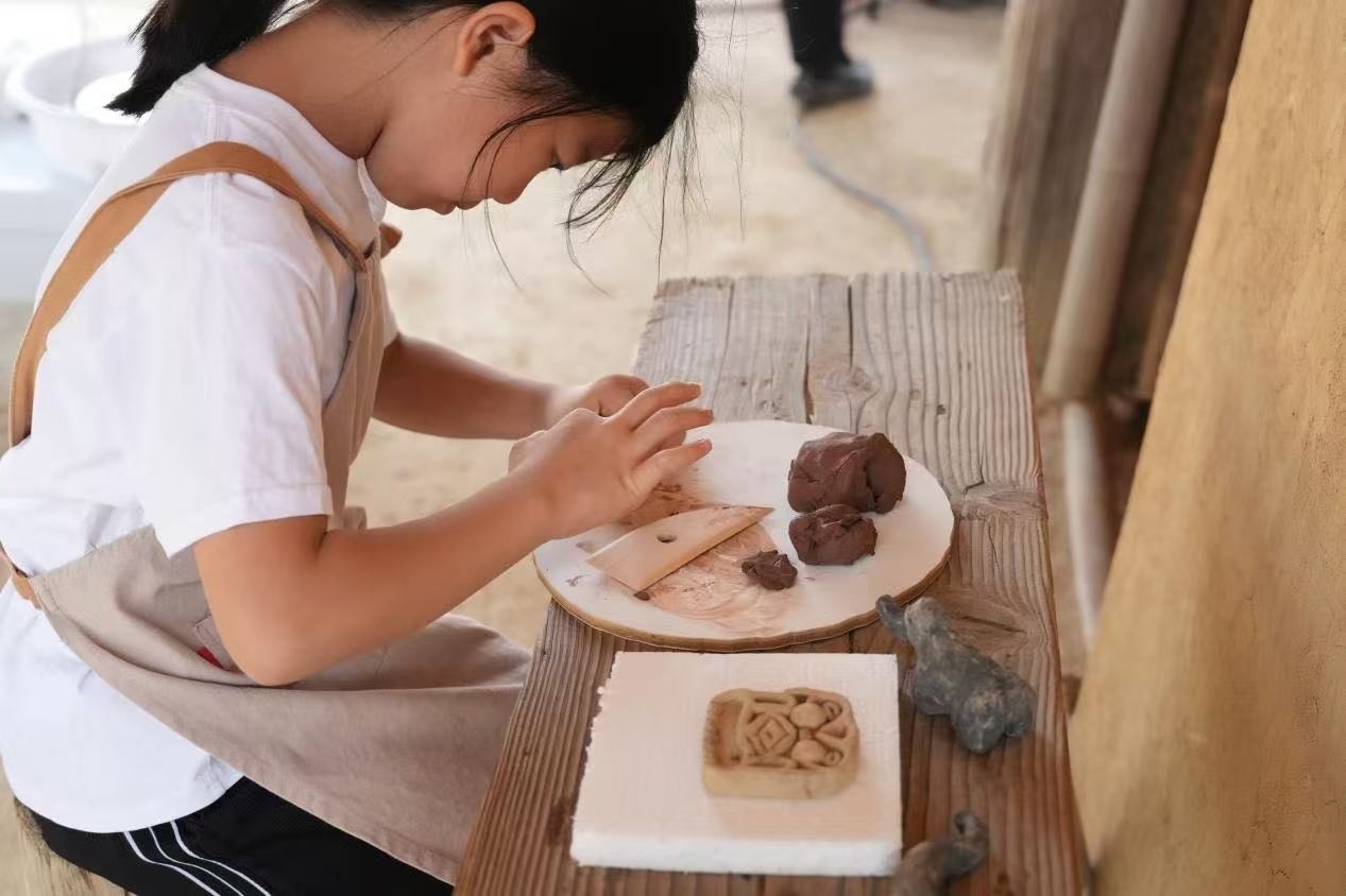 游客制作良渚特色陶藝品。良渚博物院供圖