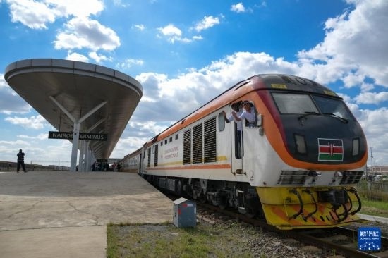 5月31日，在蒙內(nèi)鐵路內(nèi)羅畢站，機(jī)車駕駛員蔣立平（右）和博爾在即將開往蒙巴薩的E2次列車上揮手致意。新華社記者 楊光 攝