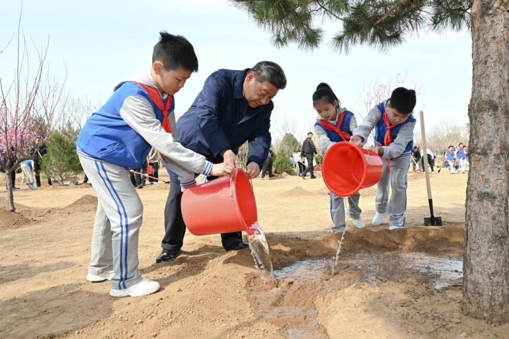 2025年4月3日，習(xí)近平總書(shū)記等來(lái)到北京市豐臺(tái)區(qū)永定河畔參加首都義務(wù)植樹(shù)活動(dòng)。這是習(xí)近平總書(shū)記同少先隊(duì)員一起給剛栽下的樹(shù)苗澆水。新華社記者 謝環(huán)馳 攝